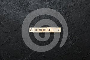 Summary word written on wood block. Summary text on table, concept