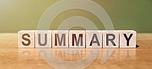 SUMMARY word written on wooden blocks on wooden table. Concept for your design