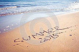 Summer 2015 handwriting on a sandy beach.