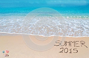 Summer 2015 written on a tropical beach