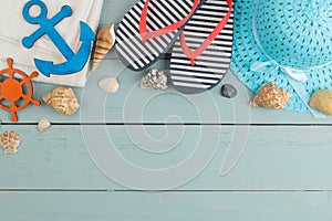 summer accessories. beach accessories. spanking, hat, shells and towel on a blue wooden table. top view. space for text