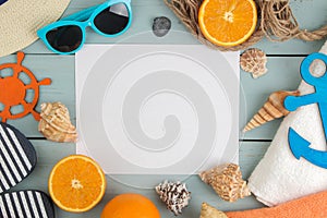 Summer accessories. beach accessories. spanking, hat, shells, towel, and sunglasses on a blue wooden table. top view. space for te