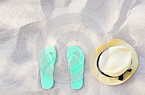 Summer accessories on beach texture banner background. Flip flops and hat on sand top view. Slippers shoes and vacation holiday