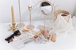 Summer accessories. Gold jewellery, sunglasses, cosmetics, perfume, lingerie, candles, boho mirror