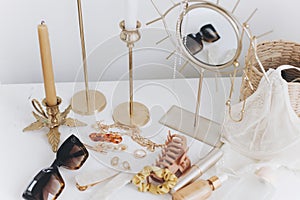 Summer accessories. Gold jewellery, sunglasses, cosmetics, perfume, lingerie, candles, boho mirror