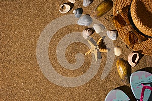 Summer accessories straw hat, glasses, shoes at the beach sand