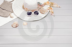 Summer accessories and tourism concept, top view on wooden background