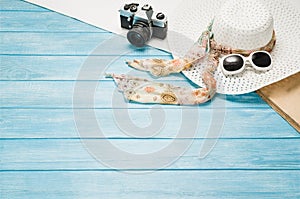 Summer accessories and tourism concept, top view on wooden background