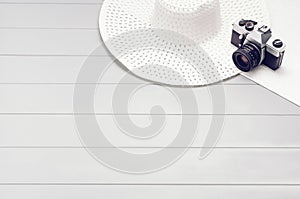 Summer accessories and tourism concept, top view on wooden background