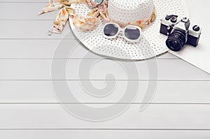 Summer accessories and tourism concept, top view on wooden background