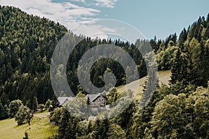 Summer alpine countryside landscape with high mountains and farms in the forest glade. Logar valley Logarska Dolina from the pan