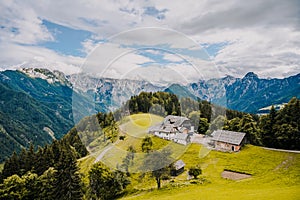 Summer alpine countryside landscape with high mountains and farms in the forest glade. Logar valley Logarska Dolina from the pan