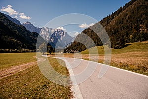 Summer alpine countryside landscape with high mountains and farms in the forest glade. Logar valley Logarska Dolina from the pan