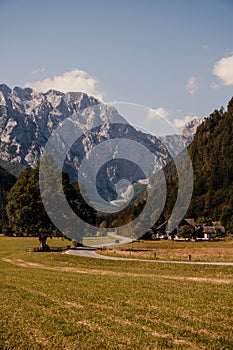 Summer alpine countryside landscape with high mountains and farms in the forest glade. Logar valley Logarska Dolina from the pan