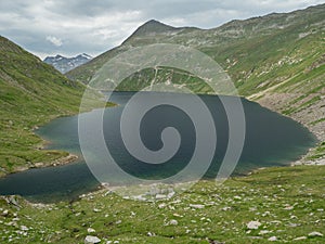 Summer Alpine landscape with lake and grassy peaks