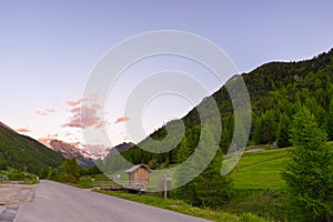 Summer in the Alps. Blooming alpine meadow and lush green woodland set amid high altitude mountain range.