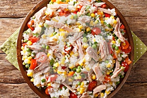 Summer appetizer salad of rice, tuna and fresh vegetables close-up in a plate. horizontal top view