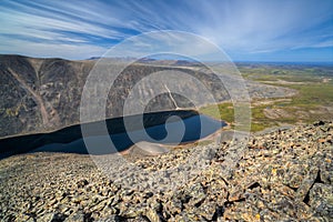 Summer arctic landscape. View from the top of the mountain to the lake, hills and endless expanses of tundra.