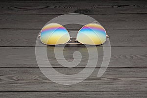 Summer aviator sunglasses with mirrored color lenses made of glass in a metal frame of gold color on a black background