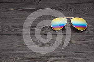 Summer aviator sunglasses with mirrored color lenses made of glass in a metal frame of gold color on a black background