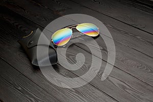 Summer aviator sunglasses with mirrored color lenses made of glass in a metal frame of gold color with a black leather case on a