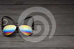 Summer aviator sunglasses with mirrored color lenses made of glass in a metal frame of gold color with a black leather case on a