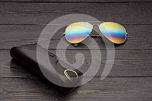 Summer aviator sunglasses with mirrored color lenses made of glass in a metal frame of gold color with a black leather case on a