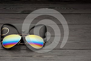 Summer aviator sunglasses with mirrored color lenses made of glass in a metal frame of gold color with a black leather case on a