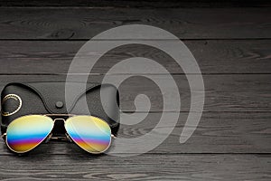 Summer aviator sunglasses with mirrored color lenses made of glass in a metal frame of gold color with a black leather case on a