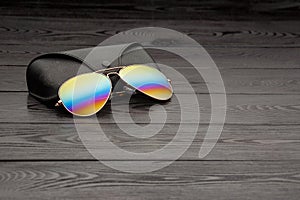 Summer aviator sunglasses with mirrored color lenses made of glass in a metal frame of gold color with a black leather case on a