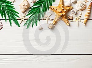 Summer background with beach sand, starfish coconut leaves, and shell decoration hanging on wooden background