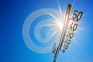 Summer background, bright sun with thermometer