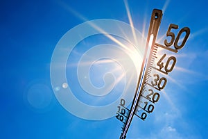 Summer background, bright sun with thermometer
