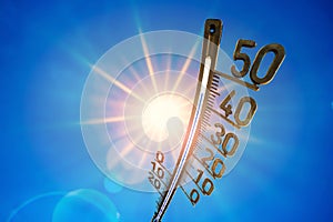 Summer background, bright sun with thermometer