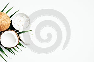 Summer background with coconut fruit and palm leaf on white background. Flat lay, top view, copy space