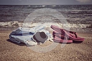 Summer background with flip flops and towel on beach