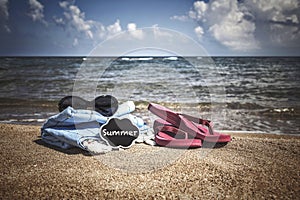 Summer background with flipflops and sunglasses on beach