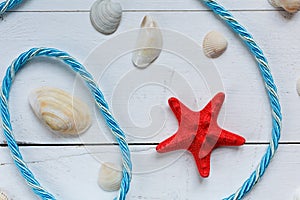 Summer background red starfish and seashells on blue wooden background. Summer vacation background