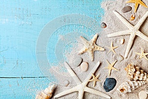Summer background from seashell, starfish and sand on blue table top view.
