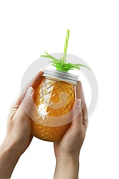 Summer background. Summer refreshing drink, juice or cocktail. Woman`s hand holding pineapple mason jar filled with