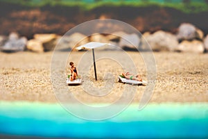 Summer background sunbather couple in deserted beach sunbathing with copy space