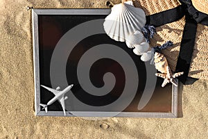 Summer background table. Globe, seashell, airplane and starfish near black desk on sea beach in sunny day. Copy space of summer