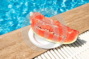 Summer background with watermelon near swimming pool. Hot summer travel, vacation and holiday concept