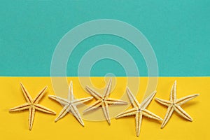 Summer background of yellow and blue paper with starfish, symbol