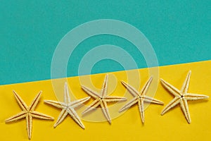 Summer background of yellow and blue paper with starfish, symbol