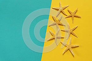 Summer background of yellow and blue paper with starfish, symbol
