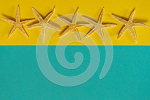 Summer background of yellow and blue paper with starfish, symbol