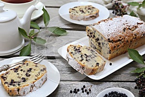 Summer baking. Black elderberry cake, teapot and cup of tea for summer tea party