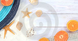 Summer banner with a hat, white mesh, shells and starfish on a wooden light background