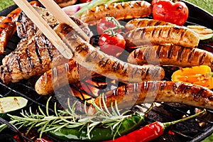 Summer barbecue with sizzling sausages over a fire